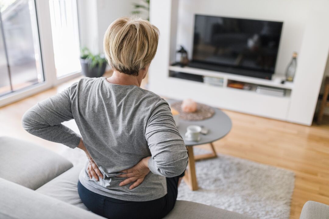A woman suffers from back pain in the lumbar region